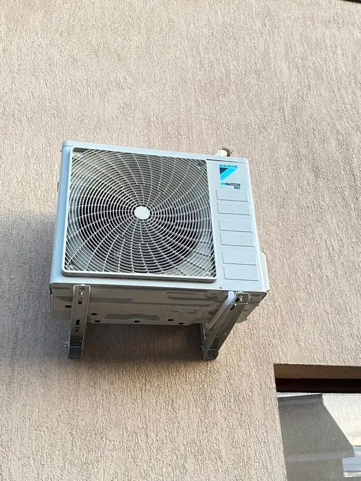 Unitatea Daikin R32 pe console, aliniată pe fațada cu tencuială decorativă