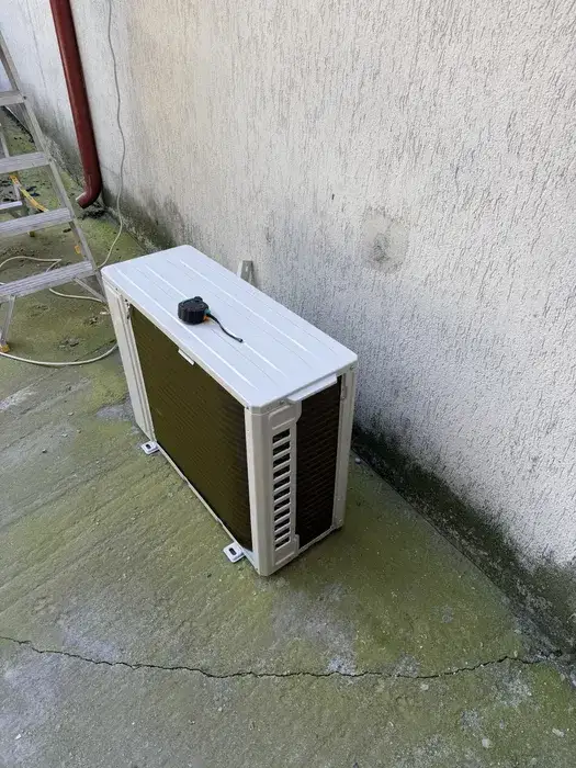 A doua unitate exterioară, pe suport la sol lângă zid, cu traseul protejat