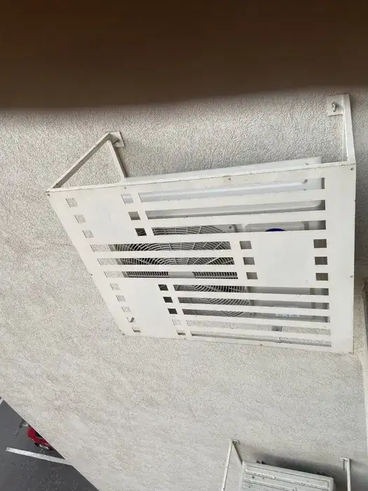 Unitate exterioară pe fațadă, acoperită cu grilaj decorativ alb